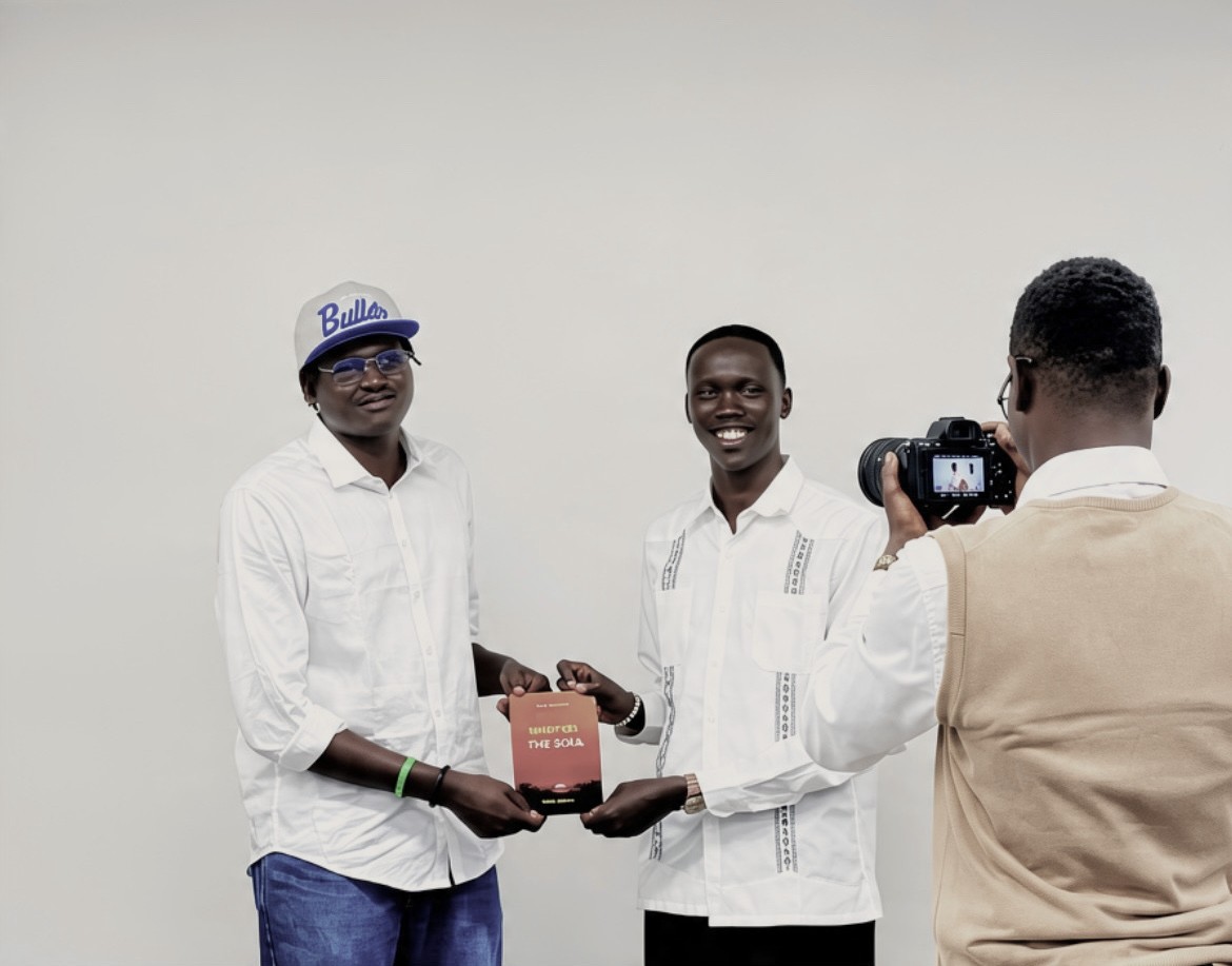 Kuol presenting a published piece of his writing to a colleague
